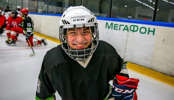 young hockey player smiles at camera