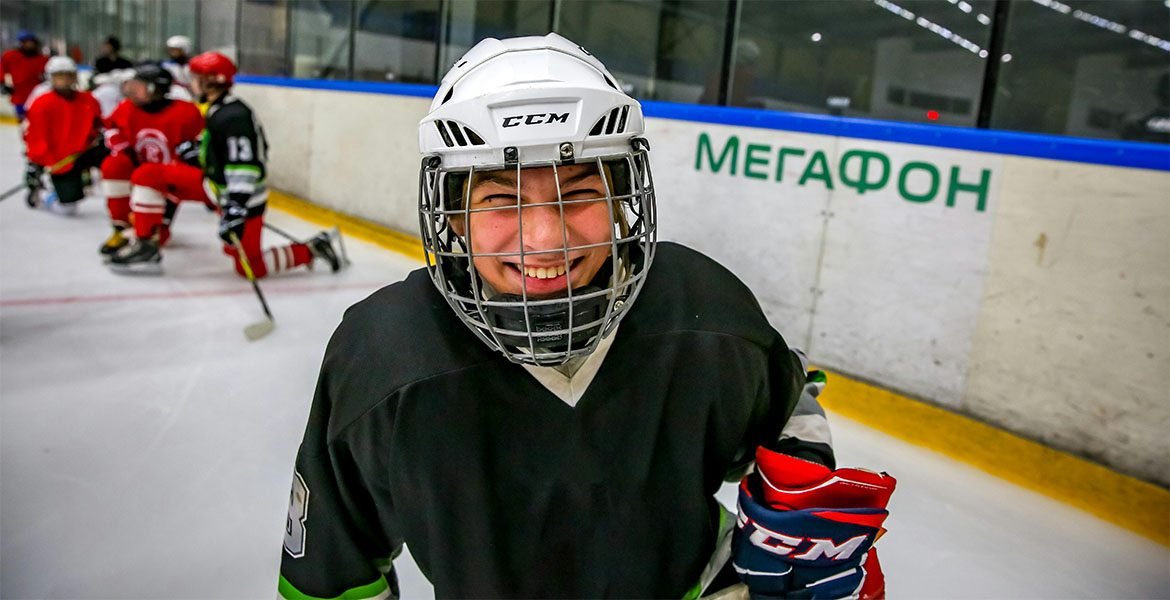 young hockey player smiles at camera